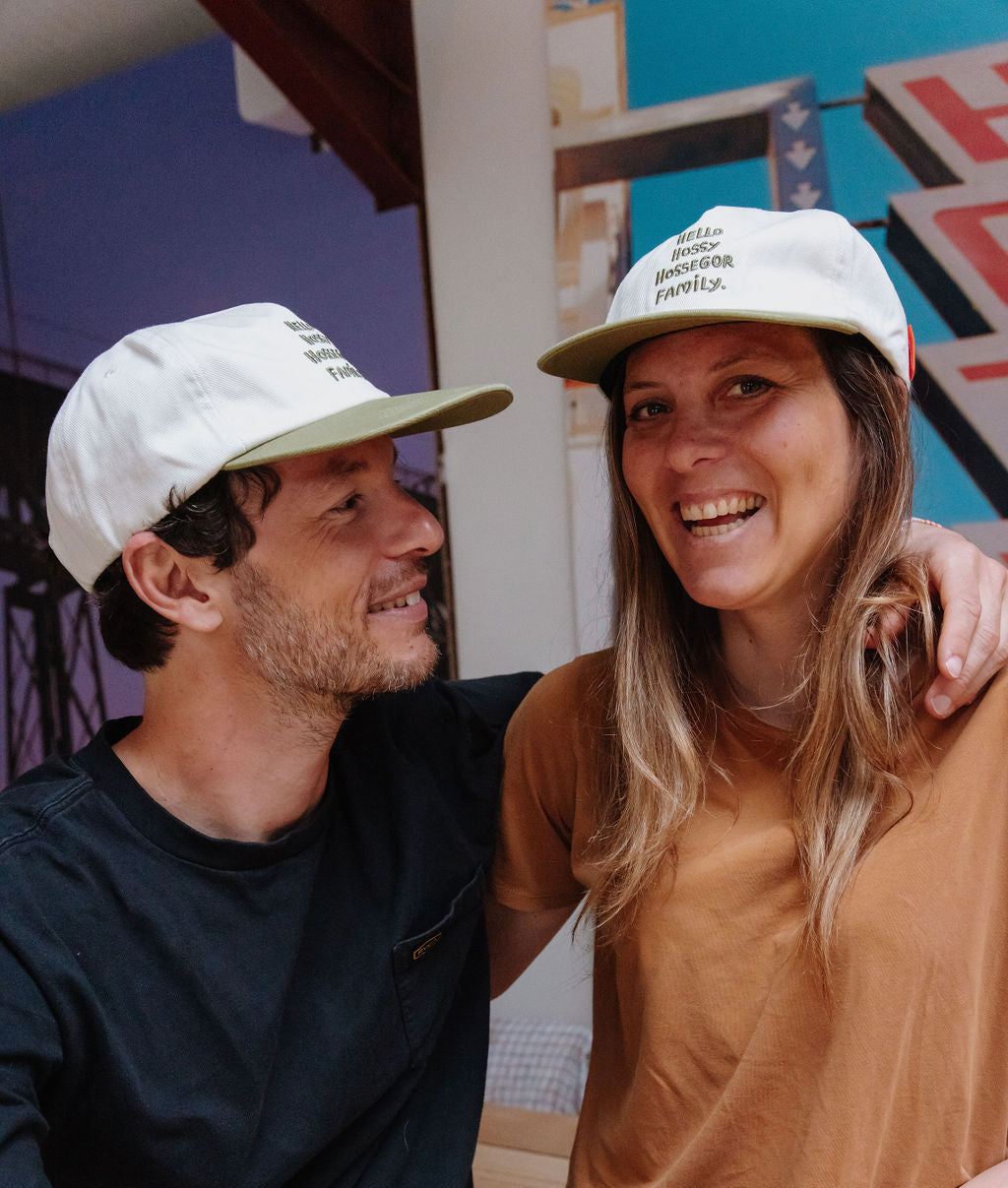 Duo papà-mamma con cappellini bianchi, visiere verdi, ricamo testo Hello Hossy