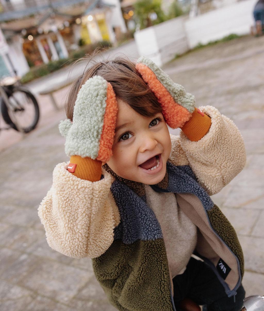 Muffole in sherpa bicolore Heaty Jim indossate da un bambino – foto lifestyle – Hello Hossy