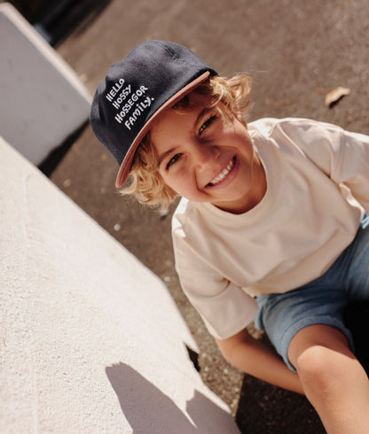 Bambino che indossa un cappellino blu e marrone con ricamo di testo e visiera curva Hello Hossy