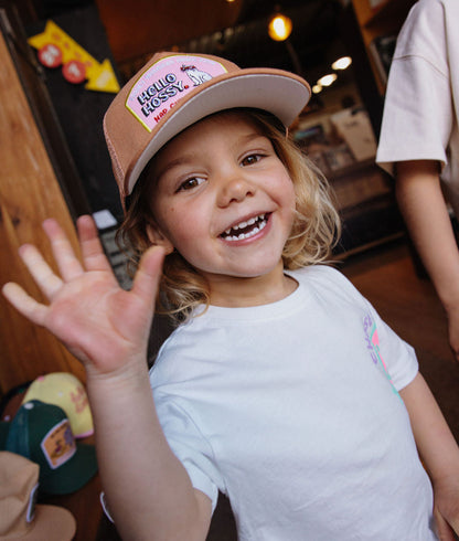 Cappellino bambino marrone con visiera piatta, patch Hello Hossy indossato da un bambino Hello Hossy