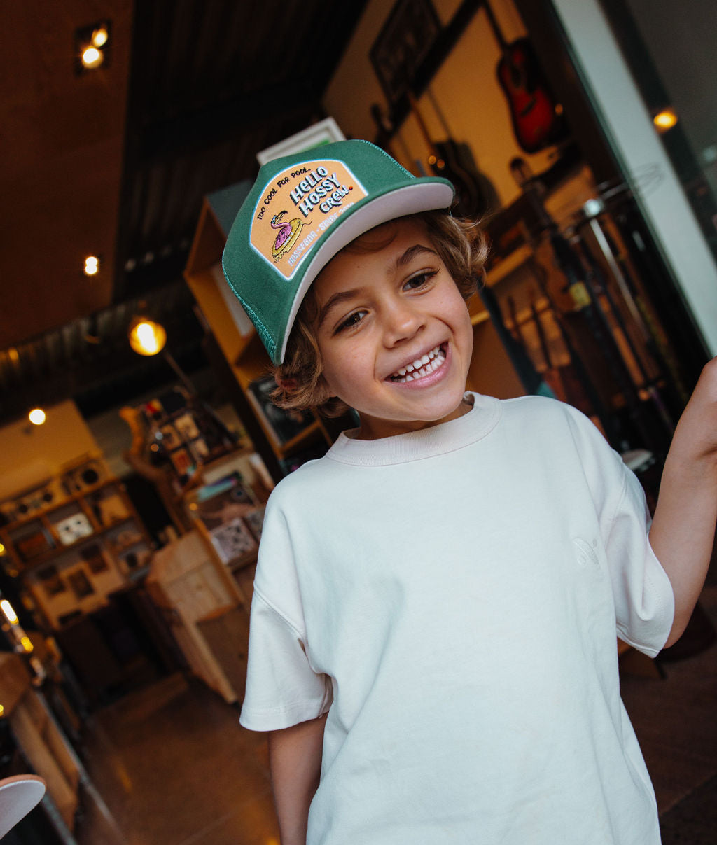 Cappellino bambino verde con visiera curva, patch Hello Hossy indossato da un bambino Hello Hossy
