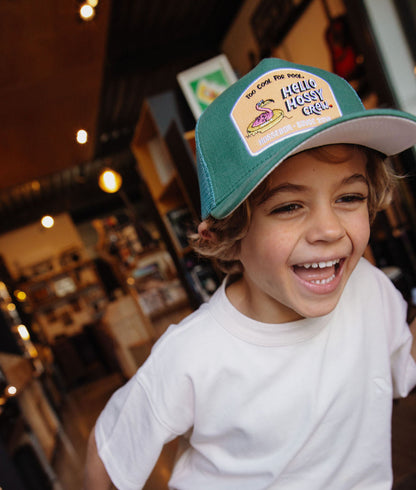 Cappellino bambino verde con visiera curva, patch Hello Hossy indossato da un bambino Hello Hossy
