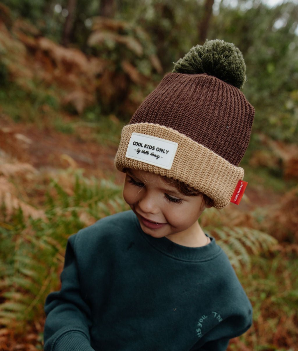 Berretto da bambino marrone con bordo Beige, pompon verde, etichetta cucita Hello Hossy