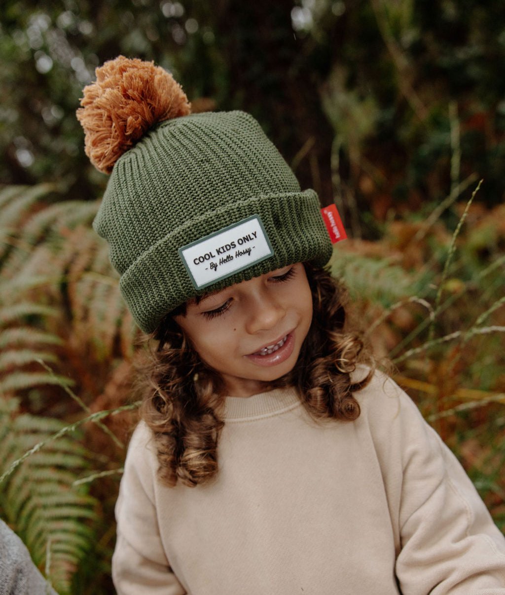 Berretto bambino verde con pompon marrone, etichetta cucita Hello Hossy
