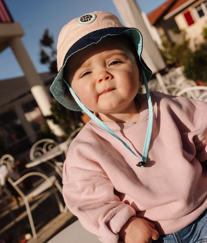 Bucket hat rosa e blu per bambini con bordo chiaro, cordino regolabile e patch rotonda Hello Hossy