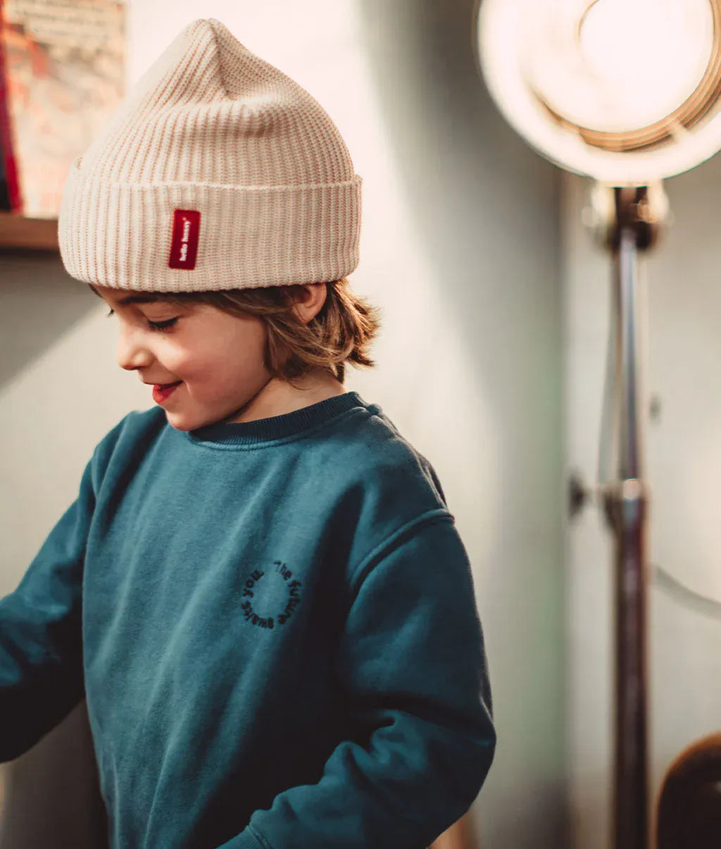 Berretto in maglia Flow Creamy indossato da un bambino – vista di profilo – foto lifestyle – Hello Hossy