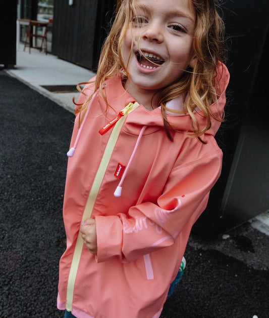 Giacca cerata impermeabile Pink indossata da una bambina - vista a 3/4 - foto lifestyle – Hello Hossy