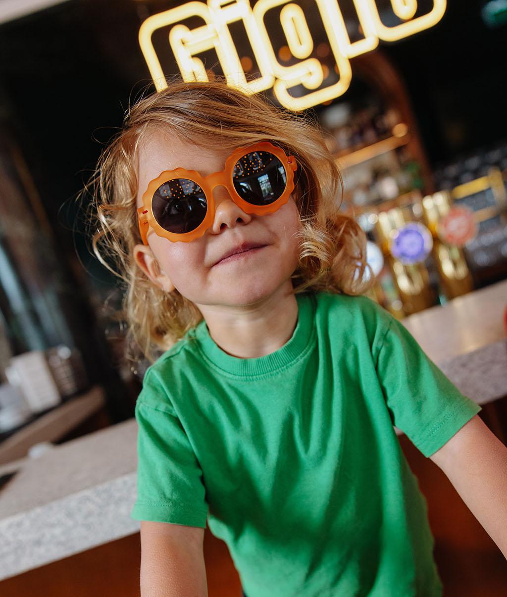 Occhiali da sole bambino arancione forma a fiore lenti scure Hello Hossy