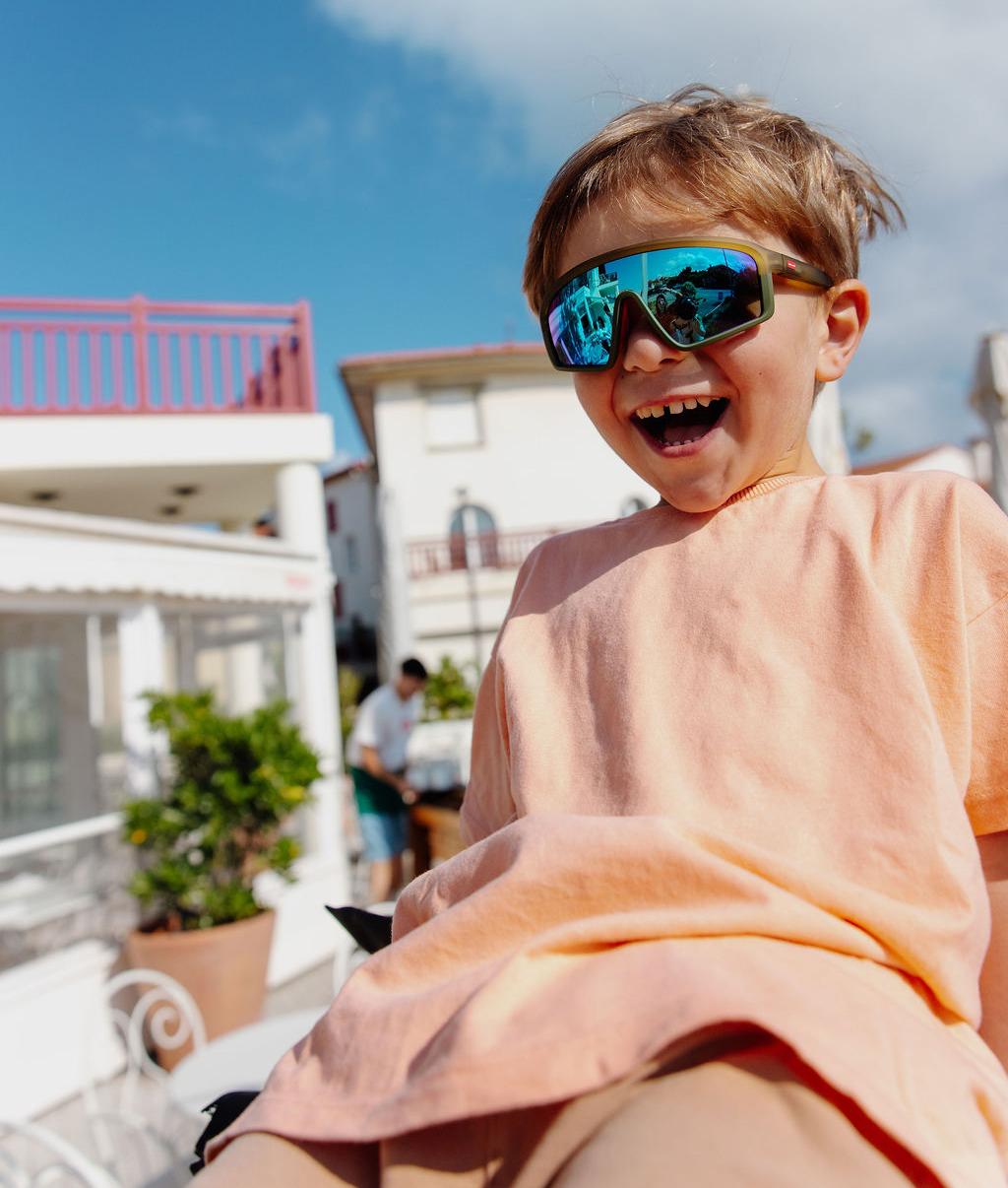 Occhiali da sole bambino verdi, forma sport, effetto specchio blu, indossati Hello Hossy