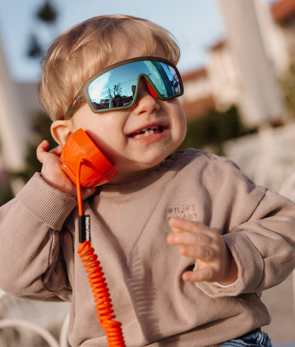 Occhiali da sole bambino verde forma sport specchio blu indossato da un bimbo Hello Hossy