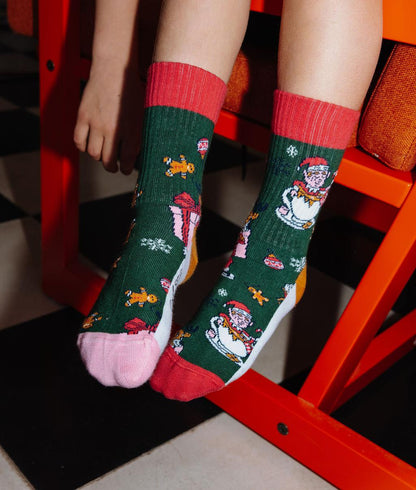 Paio di calzini verdi con motivo natale, talloni e punte colorati, indossati da un bambino – foto lifestyle – Hello Hossy