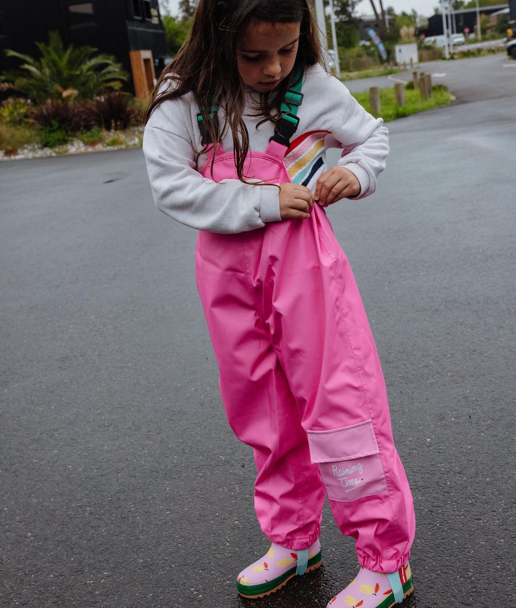 Bambina che indossa i pantaloni antipioggia impermeabili con spalline Ali – vista di 3/4 – Hello Hossy