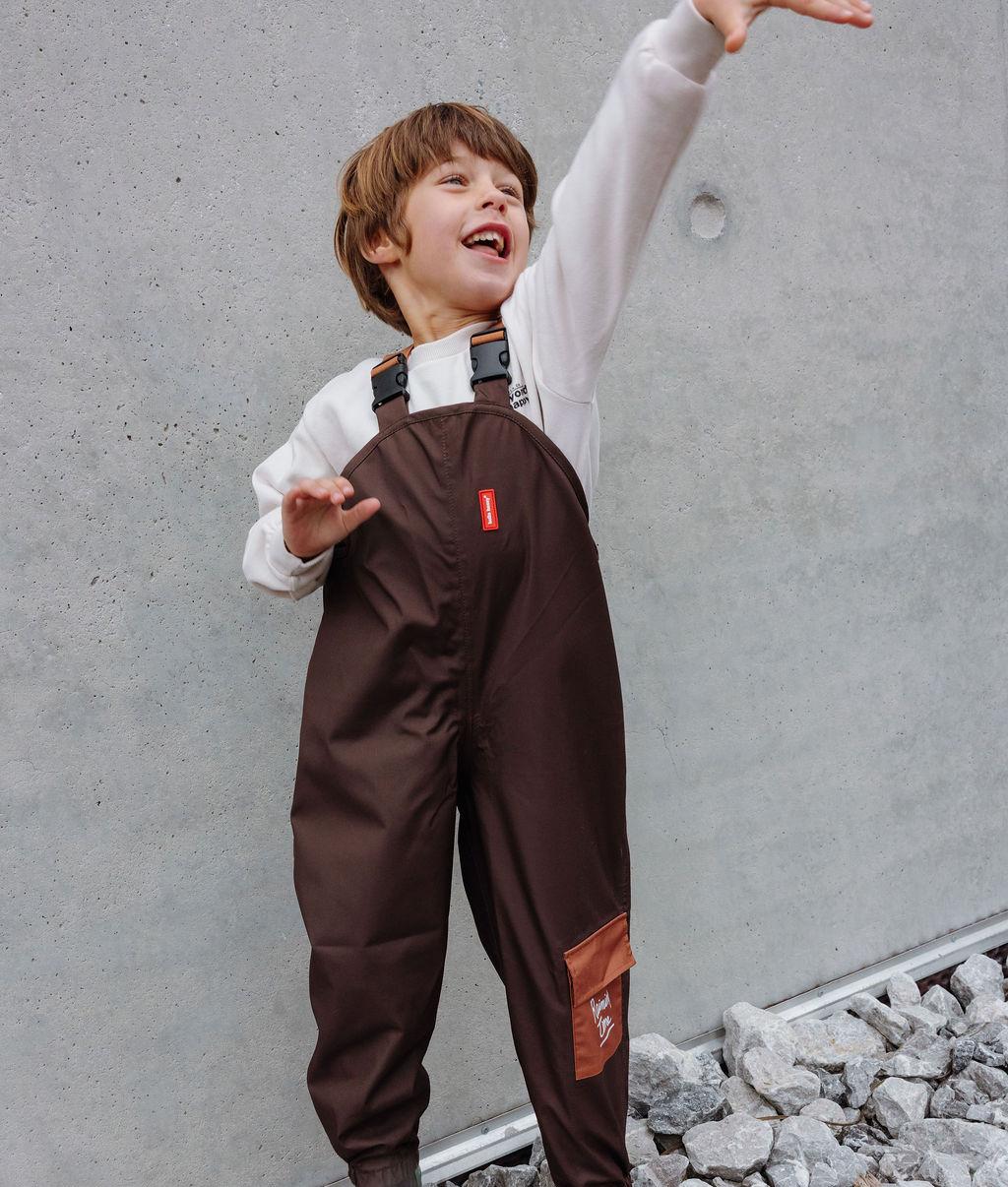 Bambino che indossa i pantaloni antipioggia impermeabili con spalline Peanut – vista frontale – Hello Hossy