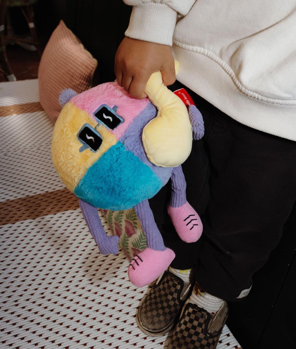 Peluche morbido Disco Pop con nota musicale in rilievo, tenuto da un bambino – vista dall'alto – Hello Hossy
