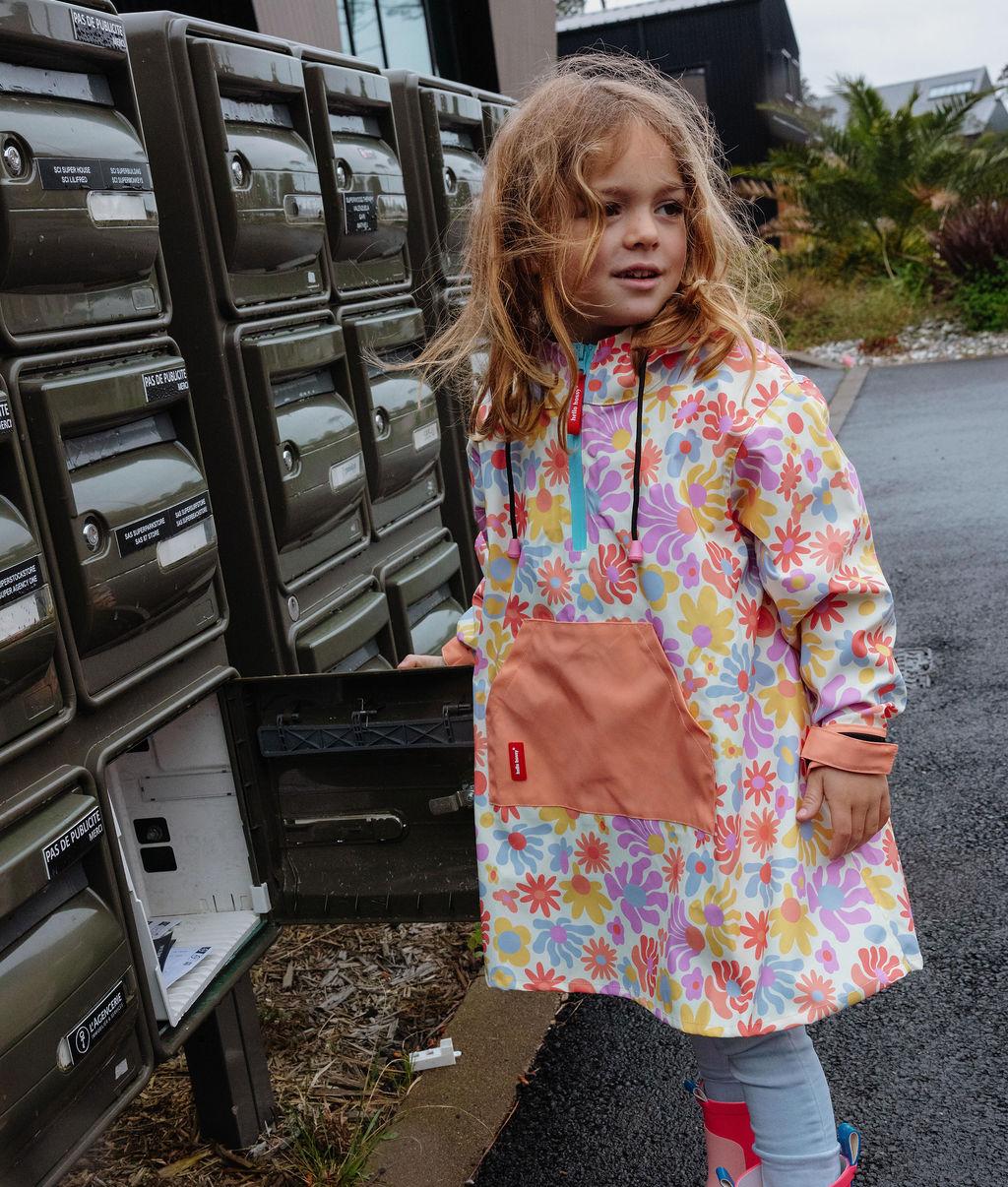 Poncho antipioggia impermeabile Retro Flowers indossato da una bambina - vista a 3/4 - foto lifestyle – Hello Hossy
