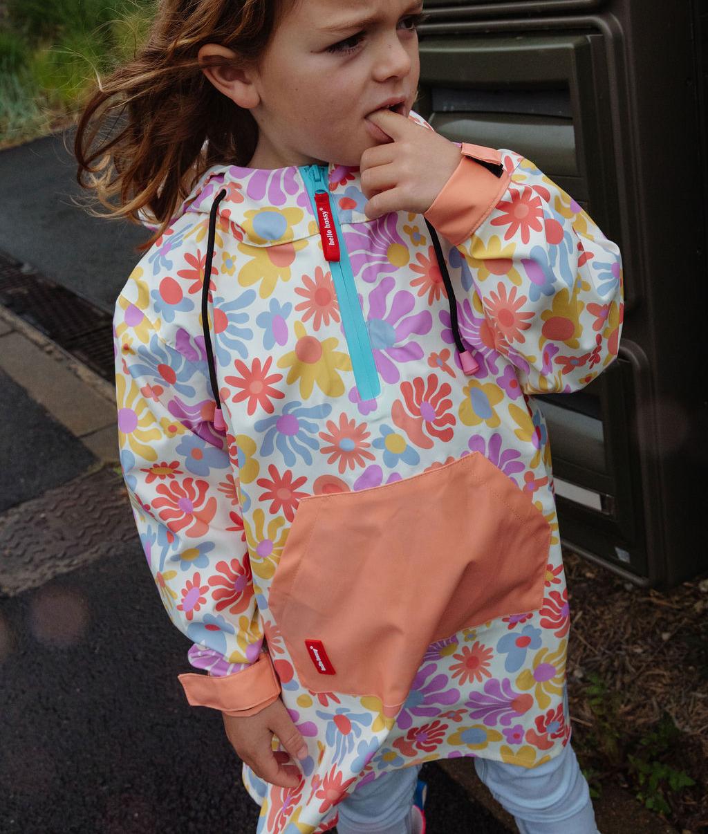 Bambino che indossa il poncho antipioggia impermeabile con cappuccio Retro Flowers – vista frontale – Hello Hossy