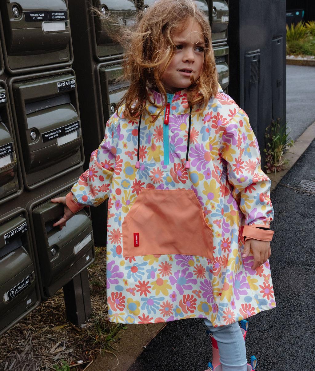 Poncho antipioggia impermeabile stampato Retro Flowers con cappuccio indossato da un bambino - vista a 3/4 - foto lifestyle - Hello Hossy