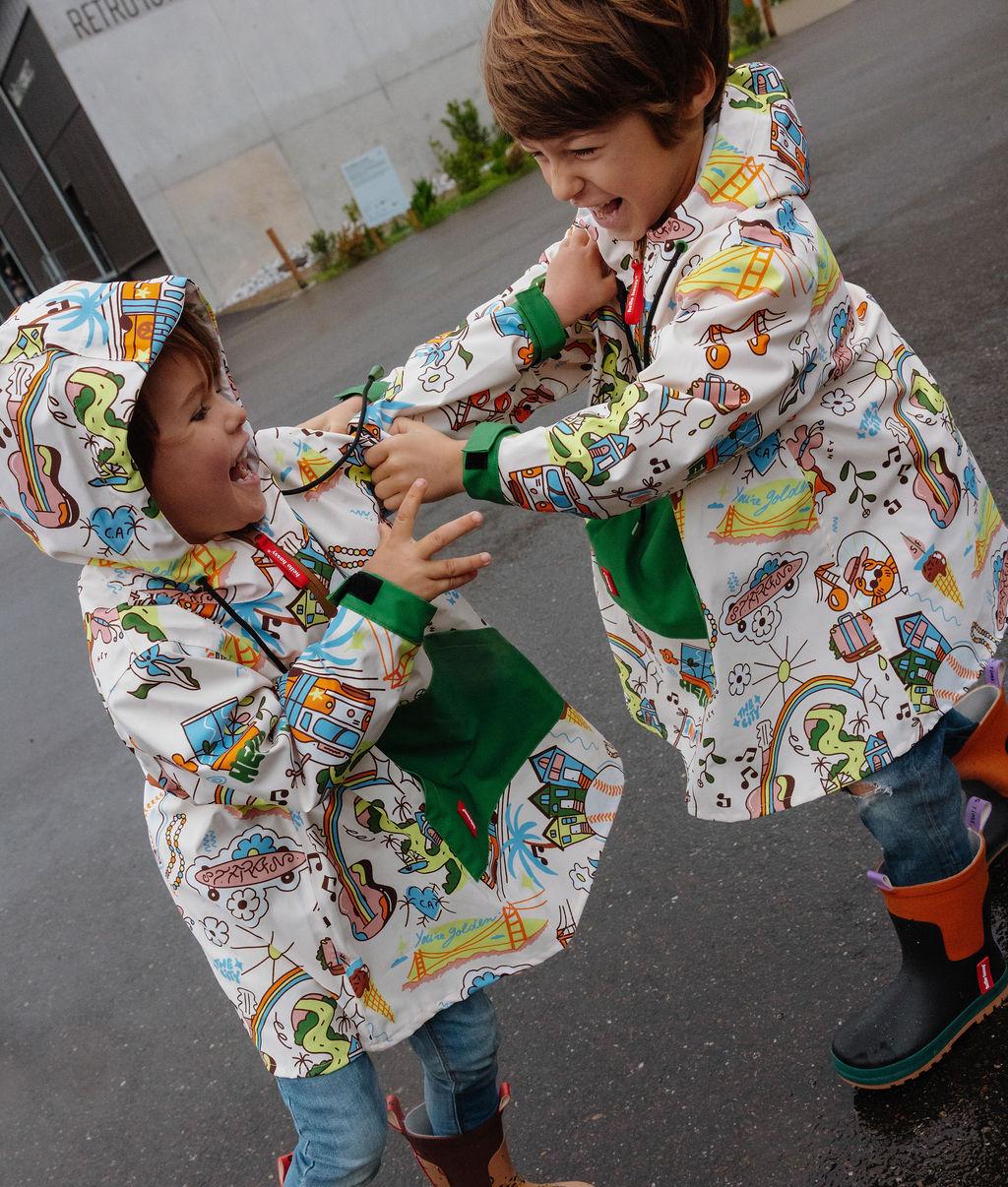 Duo di bambini con il poncho antipioggia impermeabile con cappuccio San Francisco – vista laterale – Hello Hossy