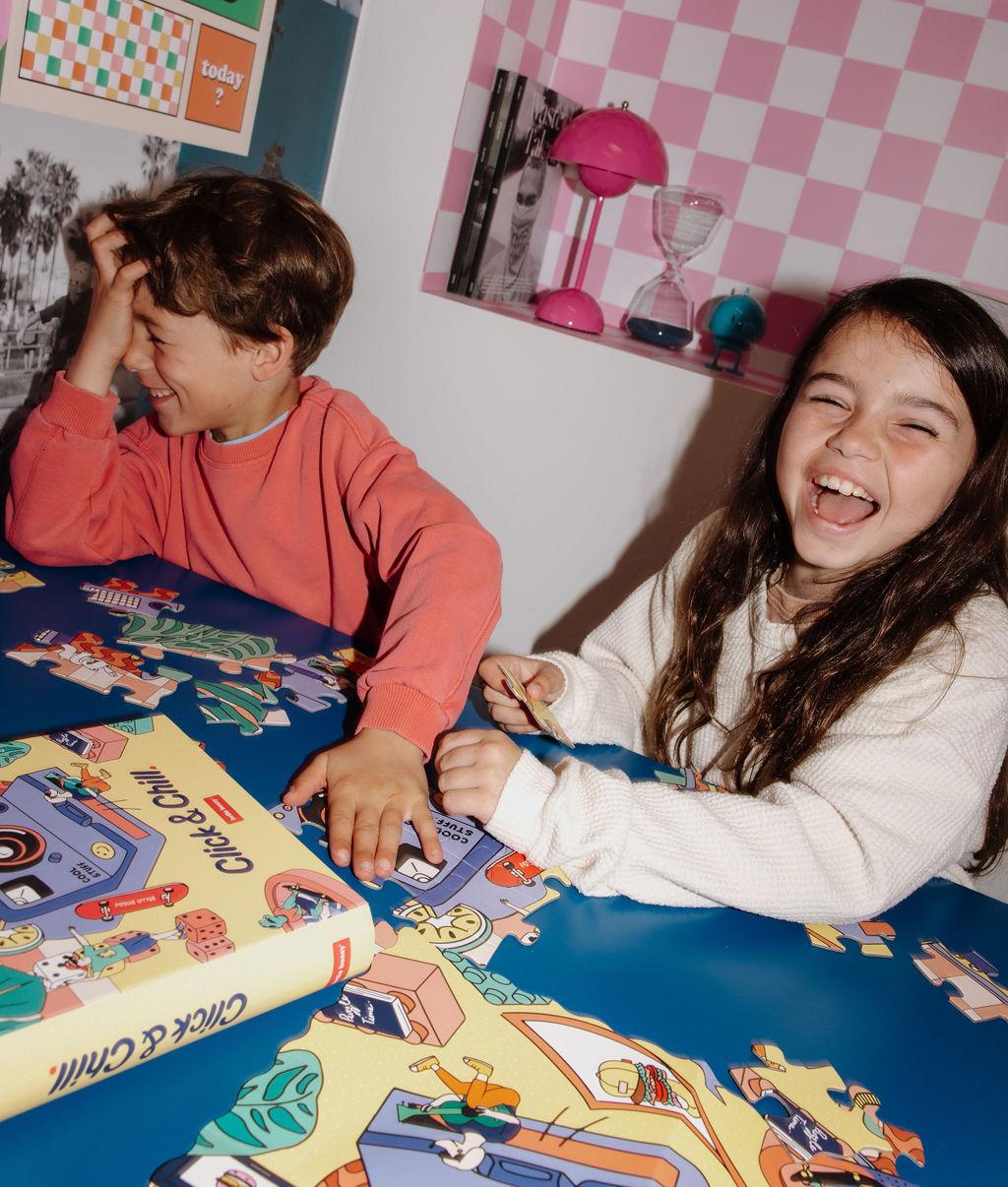 Bambina e bambino che assemblano il Puzzle colorato da 36 pezzi "Click & Chill" su un tavolo – atmosfera giocosa – Hello Hossy