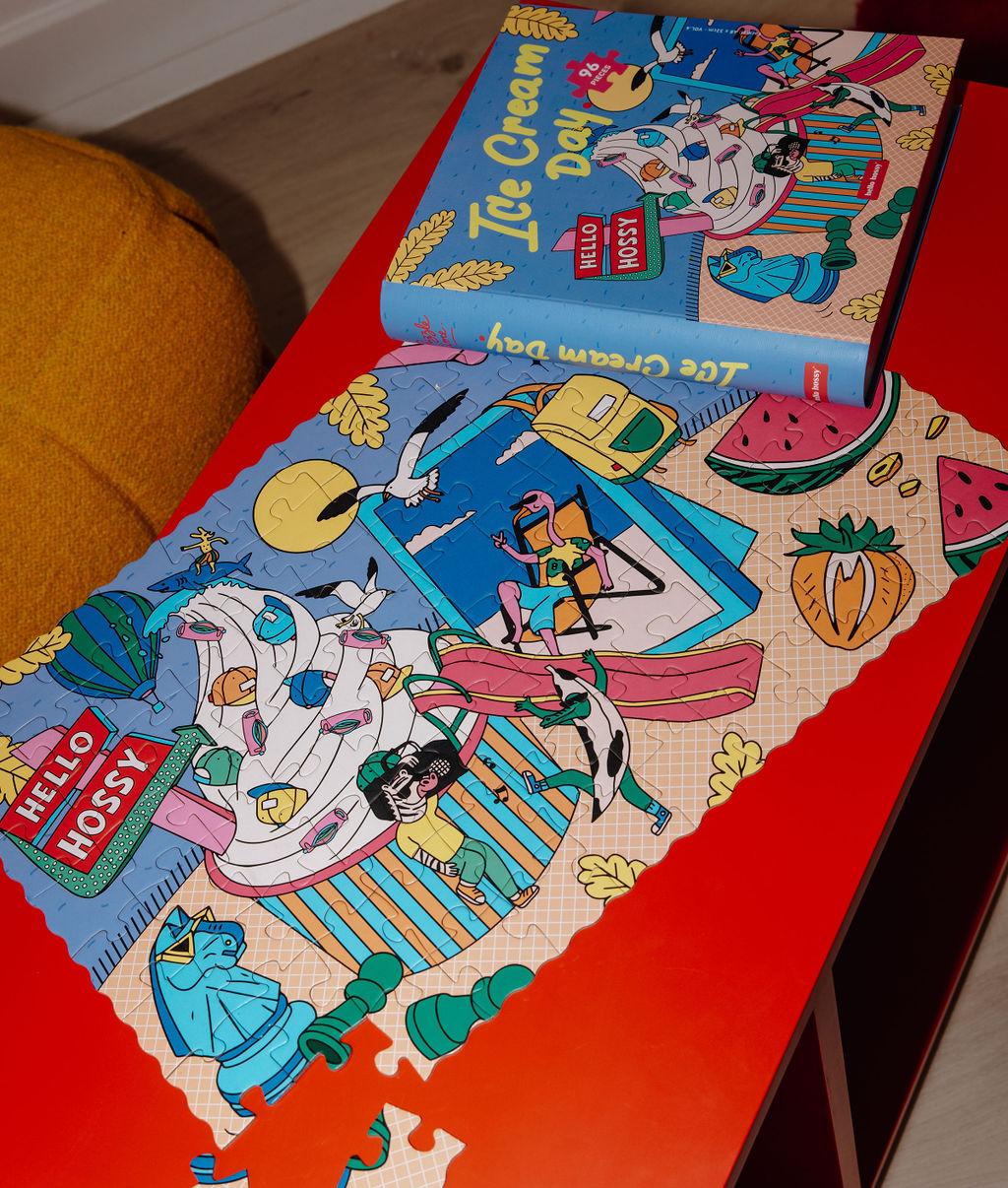 Puzzle colorato "Ice Cream Day" parzialmente assemblato su un tavolo con la scatola a fianco - vista dall'alto - Hello Hossy