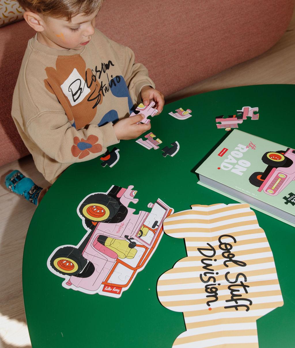 Bambino che gioca con il puzzle da 24 pezzi "On The Road" – vista dall'alto – Hello Hossy