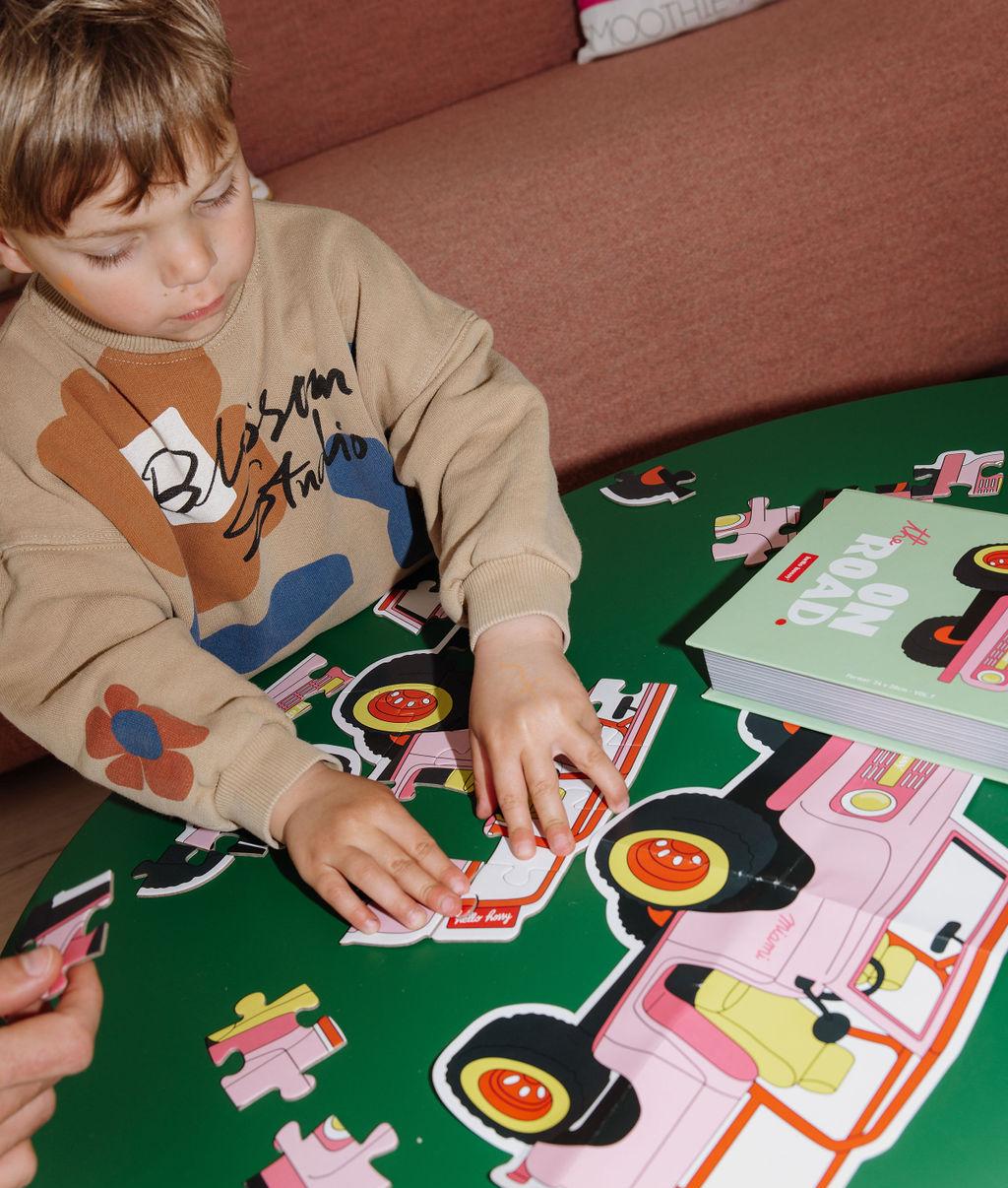 Bambino che assembla il Puzzle da 24 pezzi a forma di auto su un tavolo - foto lifestyle - Hello Hossy